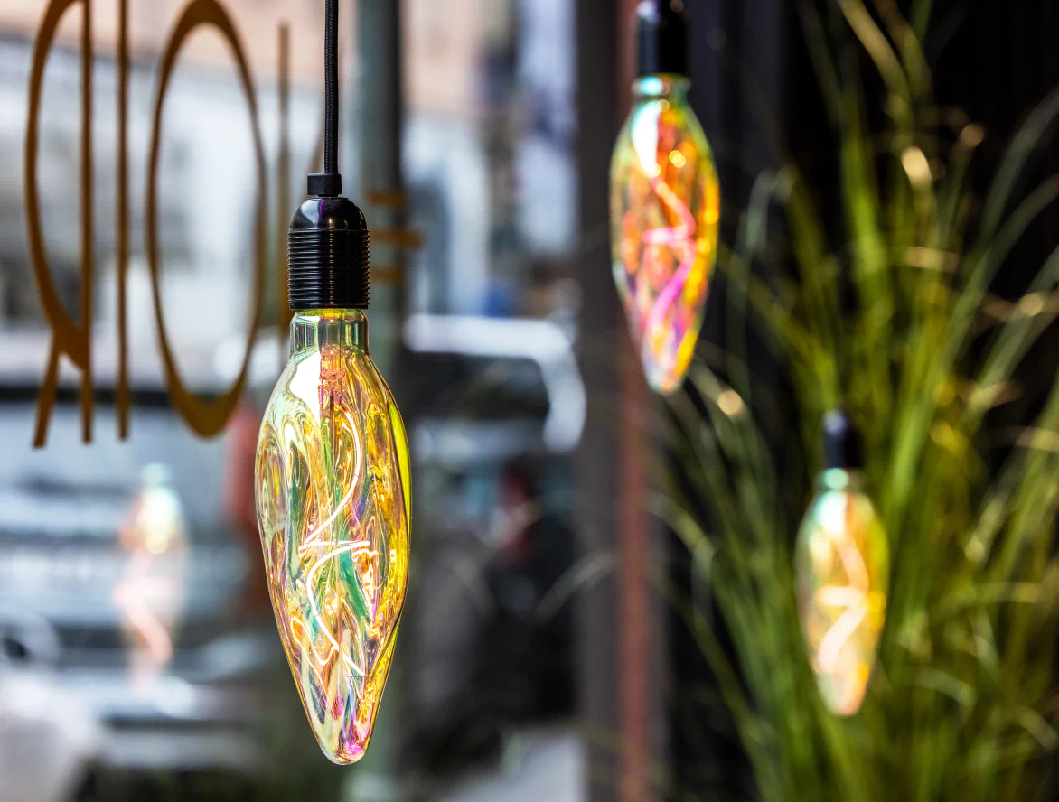 Närbild på dekorativa färgskimrande glödlampor som hänger i salongens fönster.